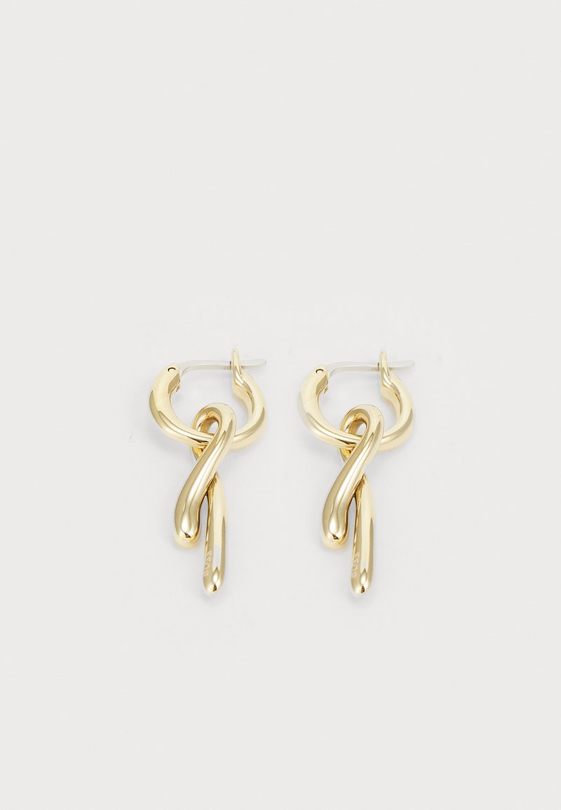 Gold-tone earrings featuring a twisted design with circular and elongated elements. Smooth texture and polished finish enhance the look.