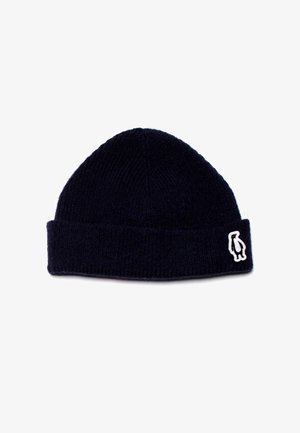 Marineblaue Rippstrickmütze mit umgeschlagenem Bündchen; verfügt über ein weißes Pinguin-Logo als Akzent an der Seite. Weicher Stoff und eng anliegende Form.