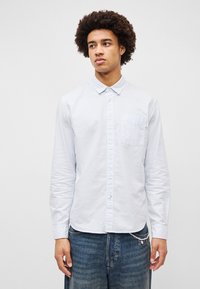 Φωτεινό γαλάζιο πουκά μισο με ρίγες από βαμβάκι, διαθέτει γιακά με κουμπιά, μακριά μανίκια, τσέπη στο στήθος και ίσιο τελείωμα.