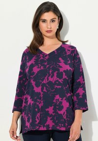 Bluzka z dekoltem w serek, z rękawem o długości trzech czwartych, w fioletowo-granatowy kwiatowy wzór, wykonana z miękkiego materiału z luźnym krojem i bocznymi rozporkami dla wygody.