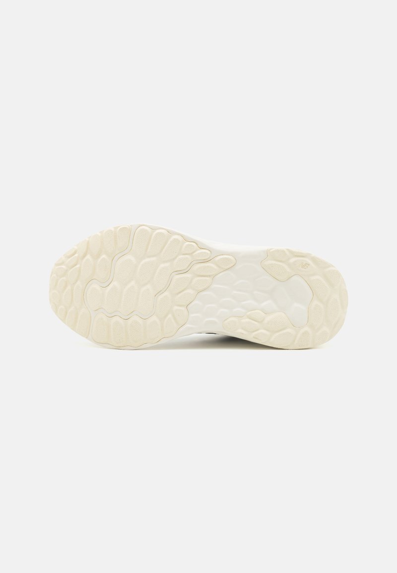 Suela de zapato con material de goma texturizado en blanco y crema, que presenta un patrón hexagonal para el agarre. Forma redondeada para mayor flexibilidad.