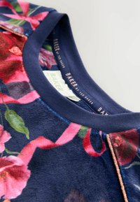 Blue floral sweatshirt with a navy ribbed neckline and glossy rose gold accents. Features vibrant pink and green floral patterns on soft fabric.