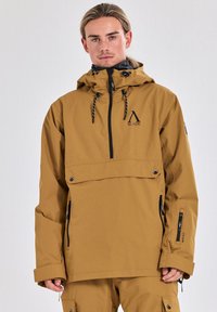 Bruine, waterdichte jas met capuchon, voorpocket en zijritsen. Voorzien van een logo en zwarte accenten. Duurzame constructie voor gebruik in de buitenlucht.