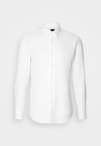 Chemise blanche pour homme à manches longues, boutonnée, col pointu et étiquette de marque visible à l'intérieur du col.