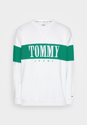 Biała bluza z szerokim zielonym poziomym paskiem na piersi i rękawach, z napisem "TOMMY JEANS" umieszczonym na środku klatki piersiowej.