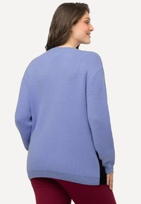 Lavendel Pullover mit lockerer Passform, gerippten Bündchen und Saum, strukturiertem Strickstoff, fallenden Schultern und kontrastierenden schwarzen Seitenpanelen.