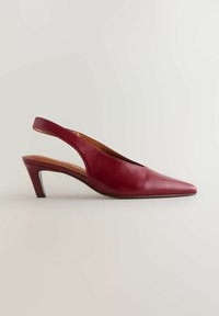 Rote Leder-Slingback-Pumps mit spitzer Zehenform und niedrigem Blockabsatz. Glatte Textur und minimalistisches Design mit Ausschnitten an den Seiten.