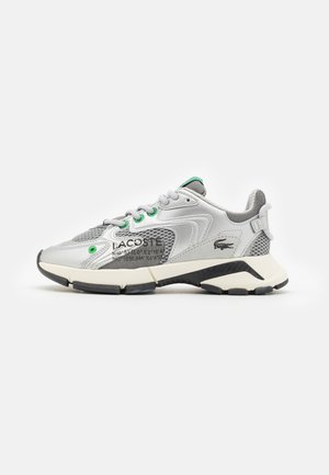 Sneakers Lacoste w odcieniach szarości i srebra, z siateczkowymi oraz syntetycznymi nastawieniami, zielonymi akcentami, teksturowanym piętkiem i czarną podeszwą. Logo po boku.