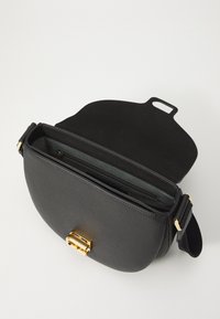 Borsa a mano nera in pelle con superficie testurizzata, hardware dorato e forma arrotondata. La parte superiore aperta rivela un interno grigio a contrasto con scomparti.
