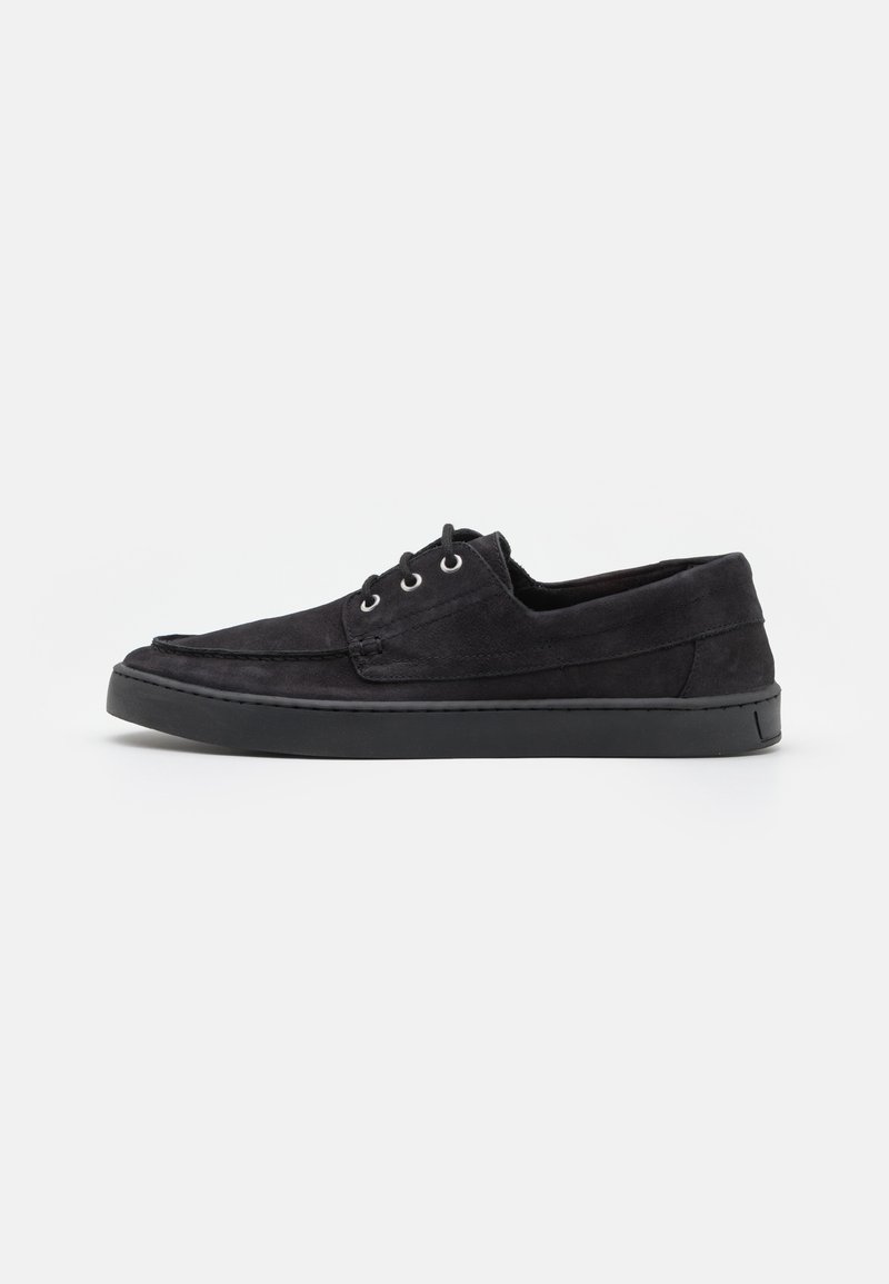 Chaussures noires en daim à lacets avec semelle en caoutchouc, présentant un bout rond et des détails de couture minimalistes. Texture lisse sur l'ensemble.