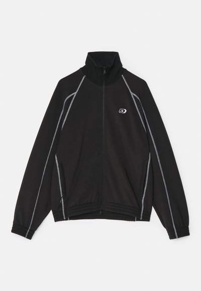 Juodas zip-up švarkas su aukštu apykakle, baltais akcentiniais siūlėmis, šoninėmis kišenėmis ir išsiuvinėtu logotipu ant krūtinės.