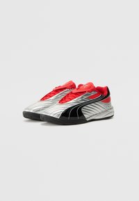 Scarpe sportive Puma in argento, rosso e nero. Presentano un design elegante con tomaia in sintetico testurizzato, chiusura con lacci e suola in gomma robusta.