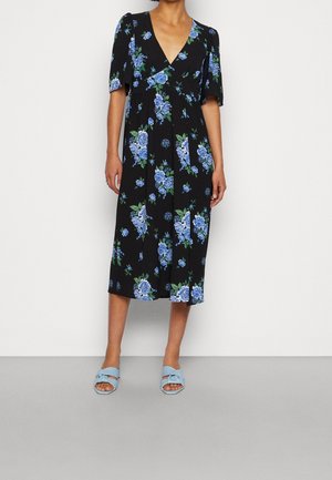Black midi dress with blue floral print, V-neck, short sleeves, worn with light blue open-toe slide sandals.