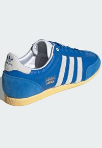 Plave kožne tenisice s antilop detaljima, bijelim prugama i zlatnim natpisom "adidas JAPAN". Imaju teksturiranu gumenu potplatu.