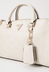 Borsa a mano in pelle bianca texturizzata con accenti dorati, dotata di manici doppi, chiusura con zip e una mini borsa staccabile. Dettaglio con logo in rilievo.