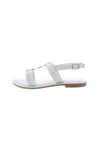 Bílé sandály se dvěma širokými pásky a sponou kolem kotníku, vybavené zlatými detaily, plochou podrážkou a prošitím podél okrajů.