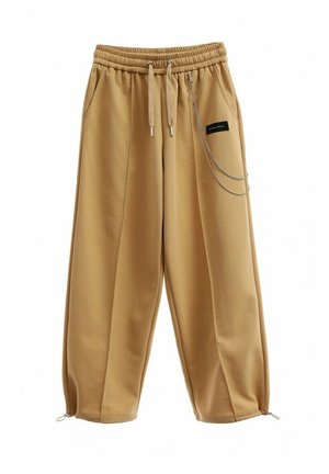 Pantalones de chándal anchos en beige con cintura elástica, cordón, bolsillos laterales y detalle de cadena en la parte frontal, que presentan una textura lisa y suave.