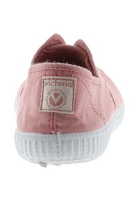 Scarpa slip-on in tela rosa con suola in gomma bianca, caratterizzata da un'etichetta con logo cucita e design con retro arrotondato, texture liscia e dettagli minimi.