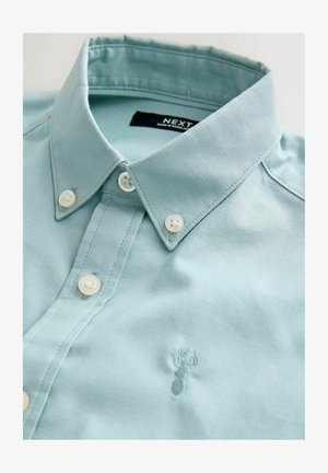 Lyseblå bomuldsskjorte med knapper, der har en foldet krave, hvide knapper og en diskret brodering af en hummer foran.