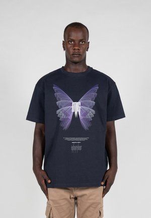 Navyblaue Baumwollt-shirt mit einem großen lila Schmetterlingsmotiv und weißem Text in der Mitte, kurzen Ärmeln und einem lockeren Schnitt.