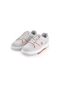 Lichtgrijze sneakers van mesh en suede, met oranje accenten, een ronde neus, een gepolsterde kraag en een witte rubberen zool.