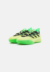 Sportssko i sort og neon grøn, med et slankt design, tekstureret overdel, polstret tunge og zigzag-mønstret sål.