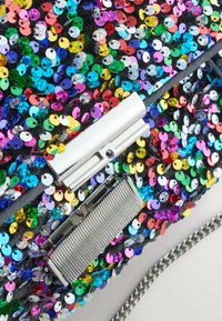 Flerfärgad paljettväska med svart bas, med ett silverfärgat lås och metalldetaljer samt en metallkedjeslinga. Skinande, texturerad yta.