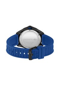Caja de reloj negra con fondo de acero inoxidable, correa de goma azul con recortes en forma de cuadrado y corona negra a las 2 en punto.