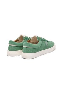 Grüne Leinensneaker mit weißen Gummisohlen, die ein einfaches Design und ein gesticktes Logo aufweisen. Weiche Textur mit runden Schnürsenkeln und einem niedrigen Schnitt.