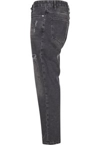 Jean en denim noir à coupe ajustée, avec des détails déchirés, un design à cinq poches et une finition décolorée.