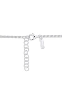 Bracelet en chaîne en argent avec un fermoir en homard et des maillons ajustables, accompagné d'une petite étiquette. Fini lisse avec une texture polie.