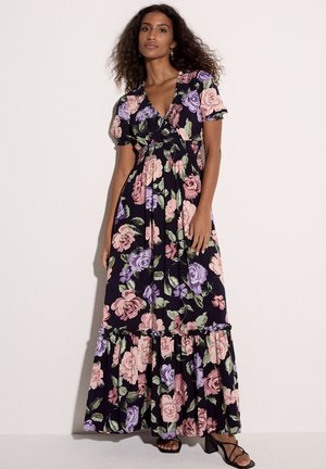 Vestido maxi floral en tela oscura con rosas en tonos rosa, morado y verde. Mangas cortas abullonadas y un dobladillo con volantes que añaden textura y detalle.
