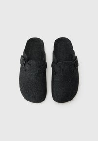 Charcoal gray felt clogs with a flat, rounded toe, a buckle strap, and a textured surface. Open back design for easy wear.