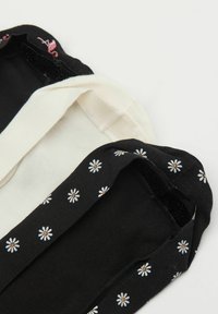 Dwie pary skarpetek z materiału: jedna w kolorze kremowym, a druga czarna w białe wzory stokrotek. Materiał jest miękki, a elastyczne brzegi zapewniają dobre dopasowanie.