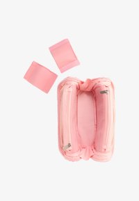 Trousse à crayons en tissu rose ouverte avec deux compartiments zippés et deux bandes de sangle amovibles assorties sur fond blanc.