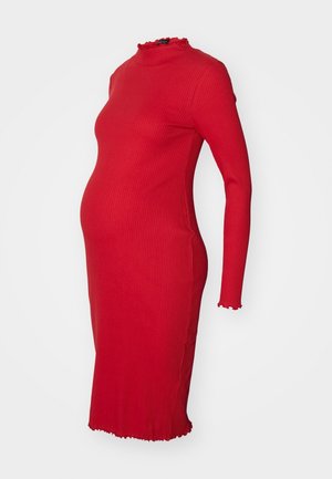 Czerwona prążkowana sukienka ciążowa z długim rękawem, wykończona falbanami na wysokim dekolcie, mankietach i dole, prezentowana na białym tle.