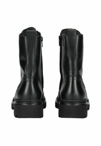 Une paire de bottes en cuir noir mi-mollet avec des talons épais, des zippers sur les côtés et des langes à l'arrière, montrées de l'arrière.