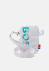 Borsa a tracolla bianca in nylon con chiusura a zip, caratterizzata da testo "BAG" multicolore, tracolla regolabile e un'etichetta arcobaleno sul lato.