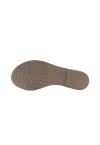 Sole of a shoe in beige rubber with a textured grip pattern and a smooth section on the heel; flat profile with rounded edges.