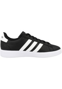 Zapatillas de deporte sintéticas negras con diseño de tres rayas blancas, suela de goma plana y punta redonda. Cuentan con cierre de cordones y cuello acolchado en el tobillo.