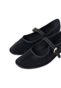 Black suede ballet flats featuring a rounded square toe, elastic strap with gold hardware, and a soft textured surface.
