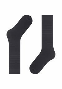 Zwarte sokken met ribbelstructuur, voorzien van een ronde teen en manchet. Eén sok is enkellang, terwijl de andere halflang is tot de kuit.