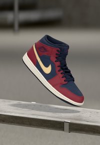 Wysokie trampki w czerwonej i granatowej skórze. Posiadają złoty znak, perforowaną część palcową oraz gumową podeszwę z teksturowanym gripem.