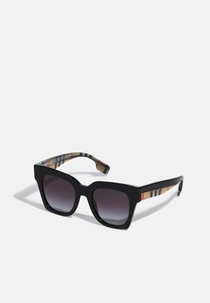 Occhiali da sole rettangolari neri con lenti sfumate. Le aste presentano un motivo a quadri nei toni del beige, rosso e nero. Montatura in plastica lucida.