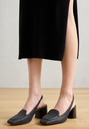 Sorte slingback sko med en tekstureret overflade, spids tå og blokhæl. Designet har en lav skæring og minimalt hardware.