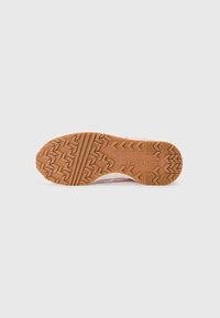 Gummisåle til sneakers har et sikksakk-mønster, beige farge med teksturdetaljer, og "Converse" merking preget.