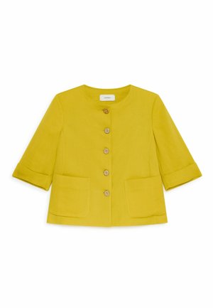 Giacca gialla corta con scollo rotondo, bottoni in legno sulla parte anteriore, maniche a tre quarti e due tasche applicate frontali su sfondo bianco.