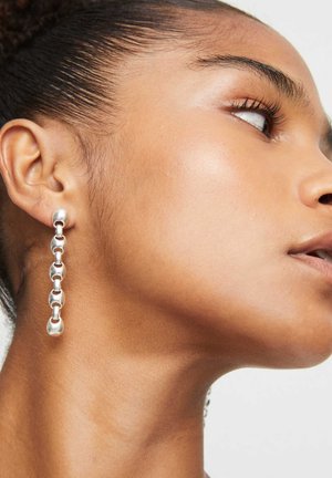Pendientes de eslabones de plata con un diseño de cadena, que presentan eslabones suaves y redondeados dispuestos verticalmente, reflejando la luz con un acabado pulido.