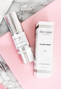 Kollagenbehandling gel och pump i elegant silver- och vit förpackning, märkta med produktinformation, vilande på en rosa bakgrund.