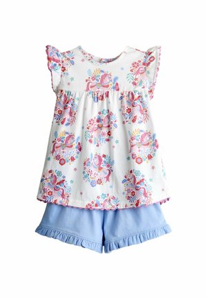 Valge varrukateta top roosa ükssarviku ja lillemustriga, mida täiendab helerohelised volangidega lühikesed püksid.